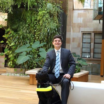 A man patting a vision assistance dog.